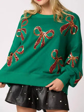 Emerald green oversized christmas sequin bow sweatshirt with sparkling red sequined bows and care instructions to tumble dry