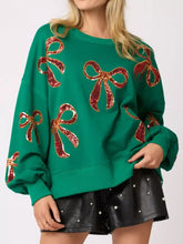 Emerald green oversized christmas sequin bow round neck sweatshirt with shimmering red and gold sequined bows care instructions include tumble dry low