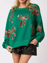 Emerald green oversized Christmas sequin bow round neck sweatshirt with shimmering red sequined bows, care instructions recommend tumble dry low
