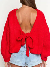 Back view of red chunky knit tie-front cardigan with deep cutout and bow