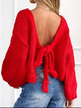 Back view of vibrant red chunky knit tie-front cardigan with deep cutout and bow