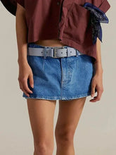 Blue denim mini skort with classic wash and light gray leather belt showcasing a stylish casual look