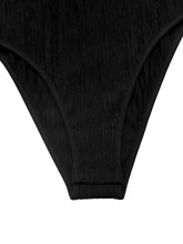 Black textured fabric thong with ribbed stretchy material and seamless stitching for cold shoulder flounce bodysuit