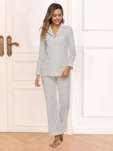 A woman wearing a light gray collared neck loungewear set with pocket featuring long sleeve length and black polka dots