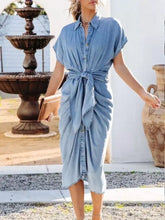 Light blue denim dress with collared neck tie and short sleeves featuring a tie waist for a flattering fit