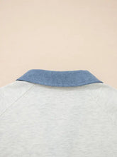 A light gray heathered long sleeve color block button top with contrasting blue denim collar