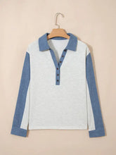 A light gray and blue color block long sleeve polo shirt with button detail and a front button-down closure