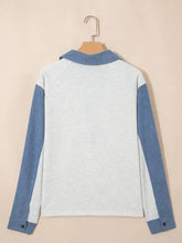 A light gray and blue long sleeve color block button detail polo shirt with contrasting collar and cuffs