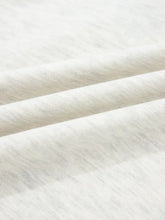 Soft white heathered cotton long sleeve top with subtle textured weave and color block button detail