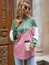 A color block casual long sleeve hoodie with white sleeves, pink and green panels, slightly stretchy fabric and machine wash care