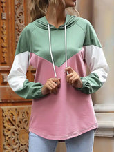 A color block casual long sleeve hoodie in mint green pink and white made of slightly stretchy material with drawstrings