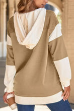 A cozy beige and cream color block knit drawstring hoodie with knit trim and contrasting sleeve length panels