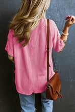 Woman in color block short sleeve ribbed V-neck top with jeans and bag