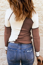 Woman in color block round neck long sleeve ribbed top and blue jeans