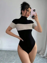 Black and beige ribbed knit color block turtleneck one-piece bodysuit with short sleeves and a fitted silhouette