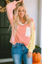 Blonde model in color block V-neck dropped shoulder sweatshirt with pocket