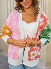 Colorful open front cardigan with pink swirls, orange florals, ribbed texture