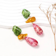 Colorful resinous dangle earrings with green amber and pink stones