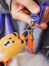 Yellow corduroy bear keychain on pet carrier sling bag