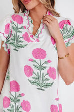 White dress with vibrant pink poppy flowers and green stems featuring contrast scallop trim layered ruffled short sleeves and scalloped neckline