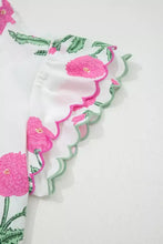 White short sleeve v neck blouse with vibrant pink floral embroidery and a contrast scallop trim layered green edge
