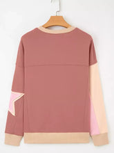 A soft rose-colored slightly stretchy sweatshirt with star patchwork, contrasting panels, and machine wash cold care