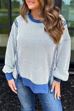 Blue and white houndstooth round neck sweatshirt with contrast stitching, ribbed cuffs, hem, collar, and care instructions