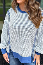 A cozy round neck sweatshirt with contrast stitching featuring a white and navy blue houndstooth pattern