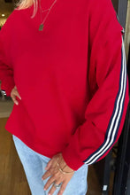 Red long-sleeved varsity sweatshirt with contrast black and white striped sleeves machine wash cold recommended