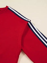 Red varsity sweatshirt with navy and white striped shoulder accents made for machine wash cold care