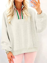 A soft heather gray sweatshirt with a colorful striped patchwork zip collar featuring green red and white stripes