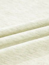 Soft off-white heathered cotton fabric showcasing gentle texture in a striped patchwork zip collar sweatshirt