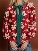 Red floral blouse with cream flowers featuring a contrast tied neck shirred puff sleeve detail and emerald green tie front