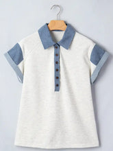 Contrast trim button detail top is a short-sleeved heathered white polo with blue collar and dark brown buttons