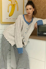 Woman in relaxed fit raglan sleeve cardigan with contrast trim button
