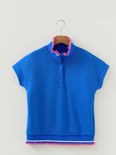 Bright blue short sleeve polo shirt with pink pom trim on collar and hem for stylish casual wear