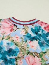 Vibrant floral blouse with contrast trim v neck cuffed bracelet sleeves in light blue with pink and teal blossoms