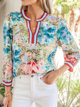 Vibrant blue and pink floral blouse with contrast red white light blue striped trim on v neck and cuffed bracelet sleeves