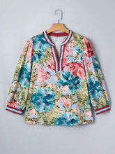 Contrast trim v neck cuffed bracelet sleeve floral blouse with vibrant blue and pink blossoms on a light background