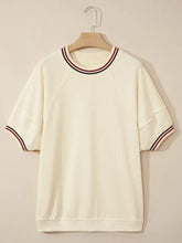 Cream-colored loose tunic top with contrast varsity striped ribbed crew neck and cuffed short sleeves