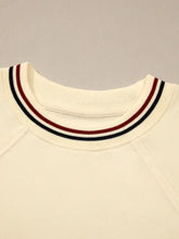 Cream-colored knit contrast varsity striped cuffed short sleeve sweater with ribbed crew neck and three horizontal stripes