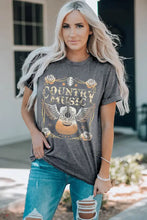 Woman in short-sleeve country music graphic t-shirt and distressed jeans