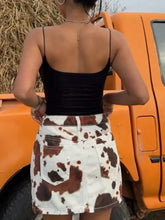 White and brown cow print denim mini skirt featuring a stylish denim mini design with bold pattern details
