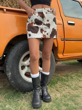 White and brown cow print denim mini skirt made of denim fabric featuring a stylish cow print design