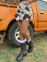 White and brown cow print denim mini skirt featuring a stylish denim mini design for casual wear
