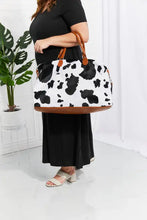 Cow print plush weekender bag with brown leather handles