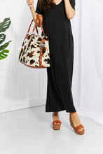 Cow print plush weekender bag with brown leather handles