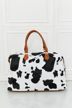 Animal print plush cow print duffel bag with brown leather handles