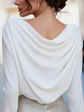 A flowing white cowl neck long sleeve blouse with a draped neckline perfect for elegant wear