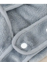 Zaino porta animali in peluche grigio con fori per le zampe e bottoni a pressione bianchi